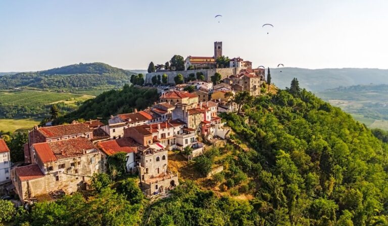 Historické město Motovun v Chorvatsku – malebné kamenné domy na kopci obklopené vinicemi a zelenou krajinou Istrie.